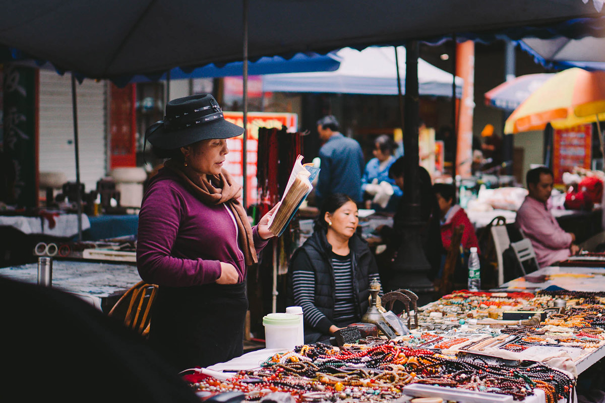 A person reading the Bible in a market.