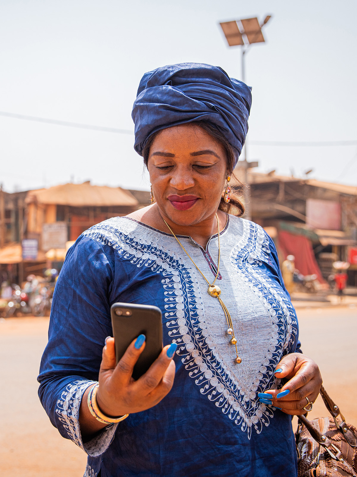 A woman on the phone. A small village in the background.